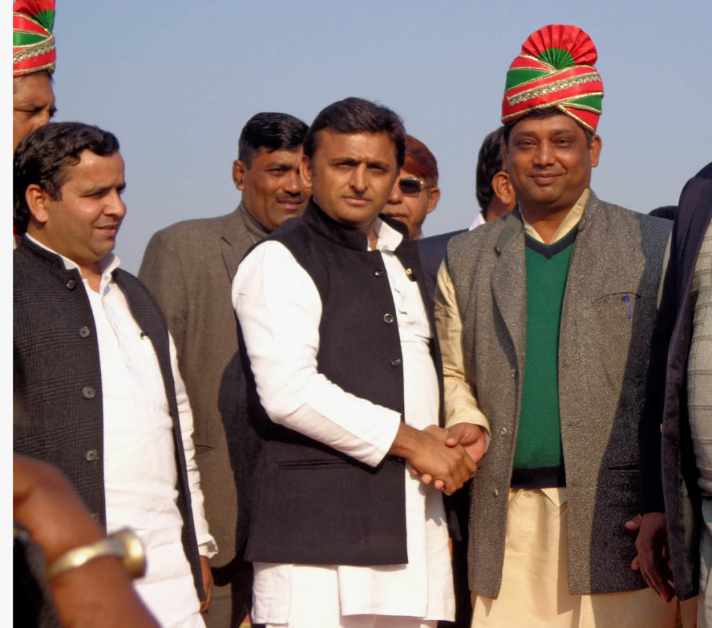 पगड़ी पहनाने के बाद पहलवान से हाथ मिलाते मुख्यमंत्री अखिलेश यादव व साथ में खड़े हैं सांसद धर्मेन्द्र यादव 