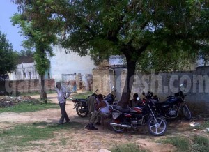 मंदिर के सामने ही दाईं ओर बनियान पहने बैठी पुलिस निगरानी करते हुये। 