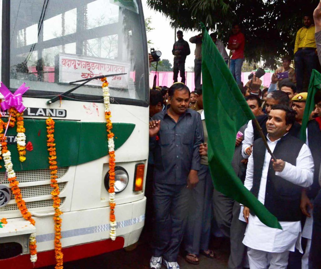 हरी झंडी दिखा कर बस रवाना करते सांसद धर्मेन्द्र यादव।