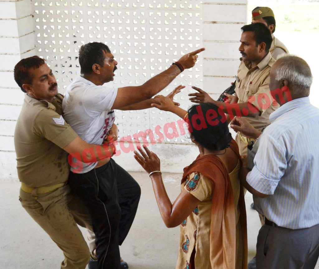 पुलिस ऑफिस पर आत्म हत्या का प्रयास करने वाले पीड़ितों को पकड़े पुलिस।  