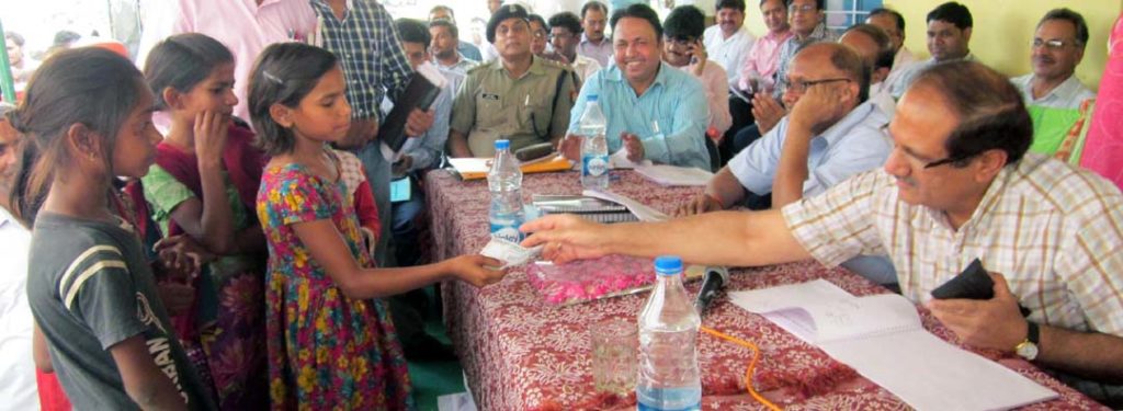 कक्षा पांच की छात्रा गोमती को सौ रूपये देते मंडलायुक्त प्रमांशु।