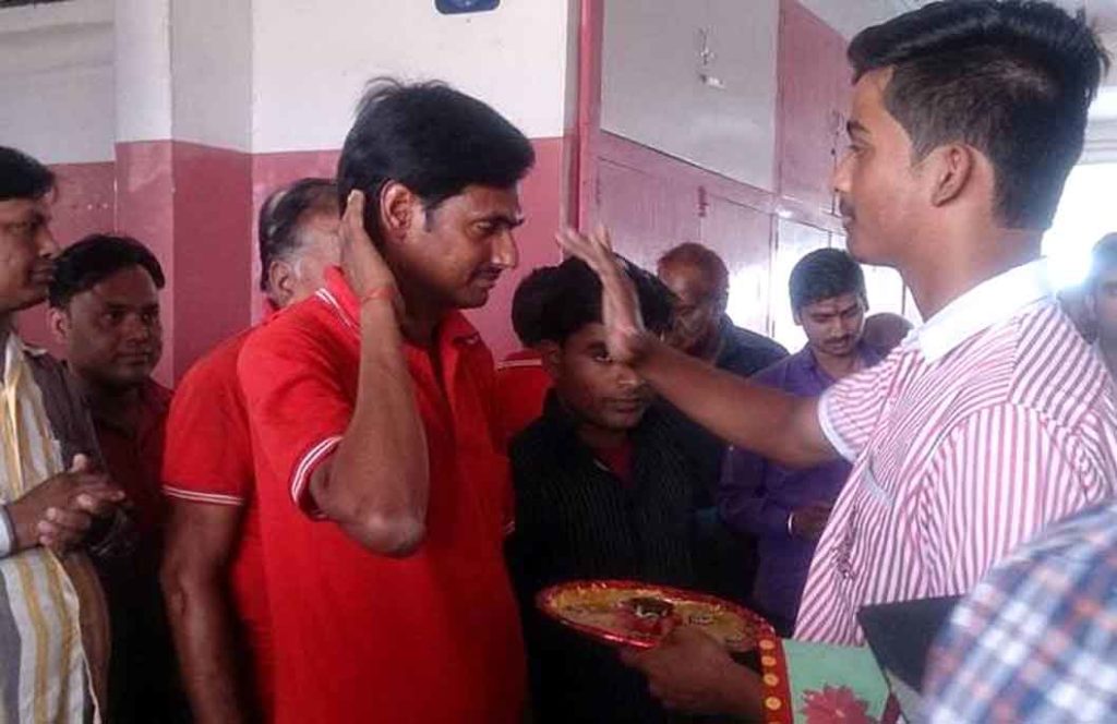 मजदूर का तिलक लगा कर सम्मान करता विद्यालय परिवार।