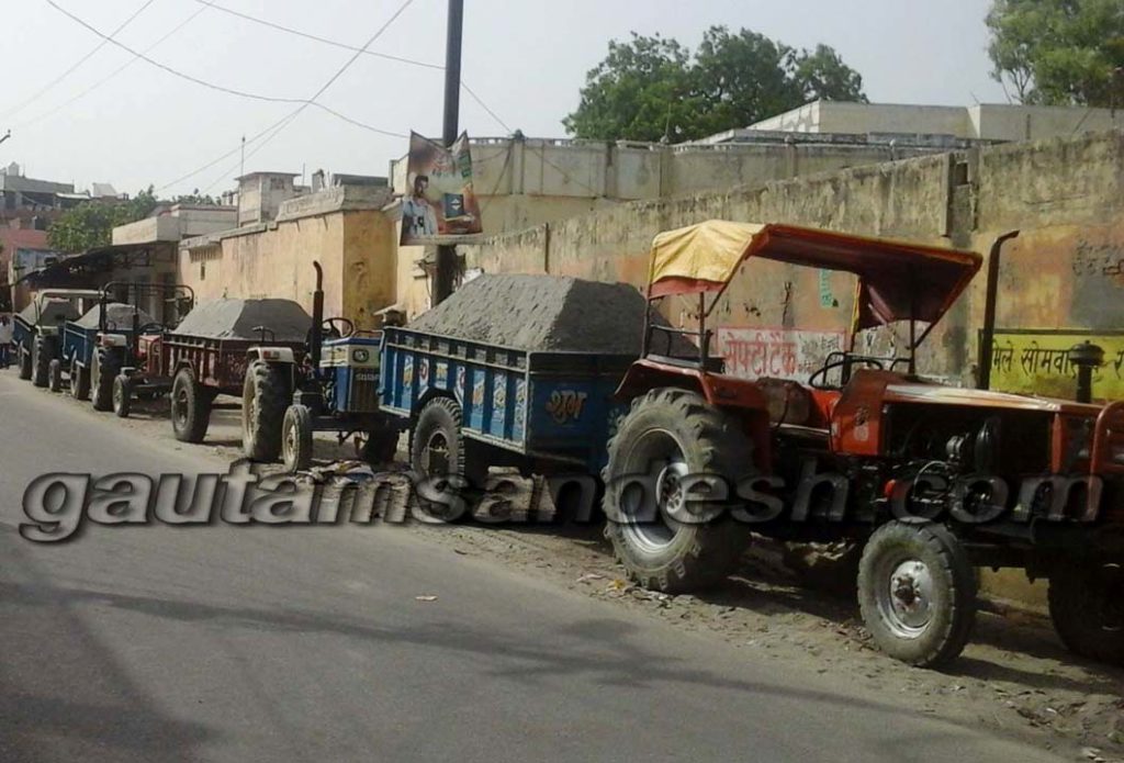 गंगा से रेत भर कर लाये गये ट्रैक्टर-ट्राली।